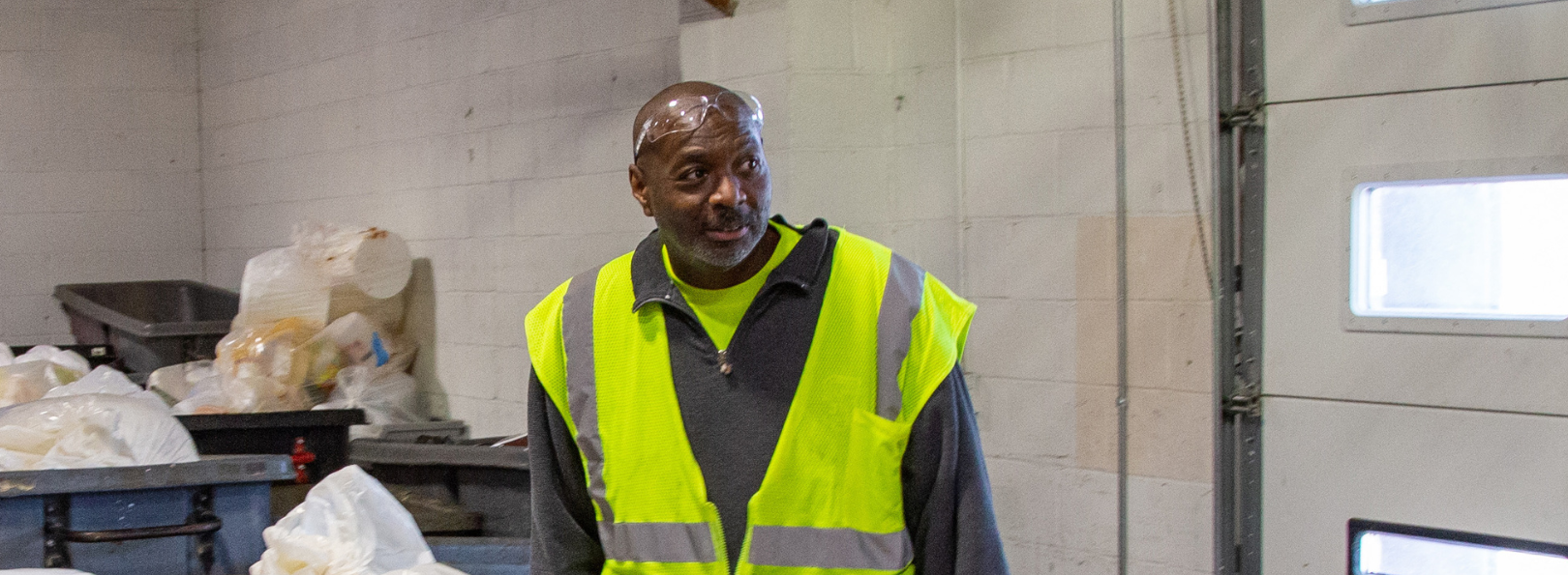 Dwayne Holmes in the recycling facility with a cart