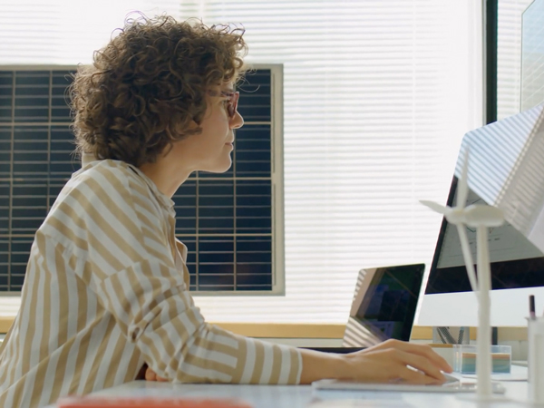 Female Renewable Energy Developer Working In Office With Solar Batteries