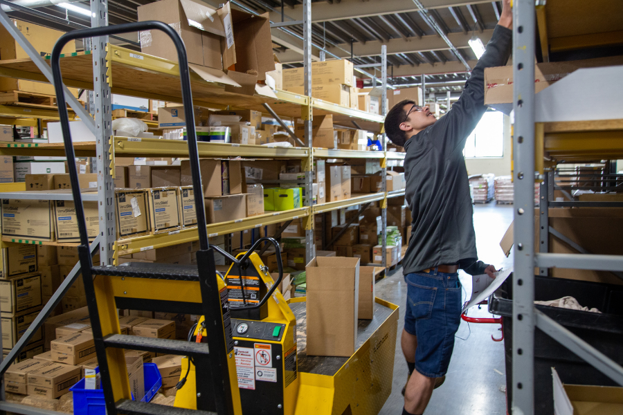 Seth Lopez reaching for a package in the warehouse